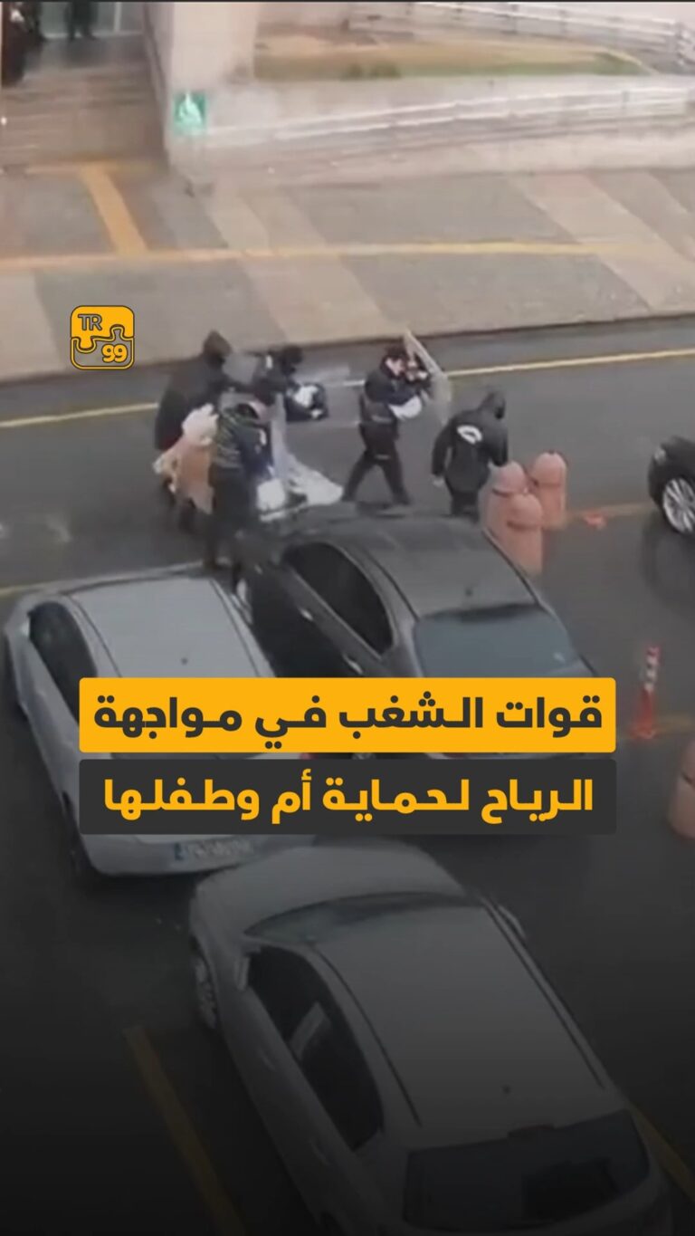 قوات الشغب في مواجهة الرياح لحماية أم وطفلها